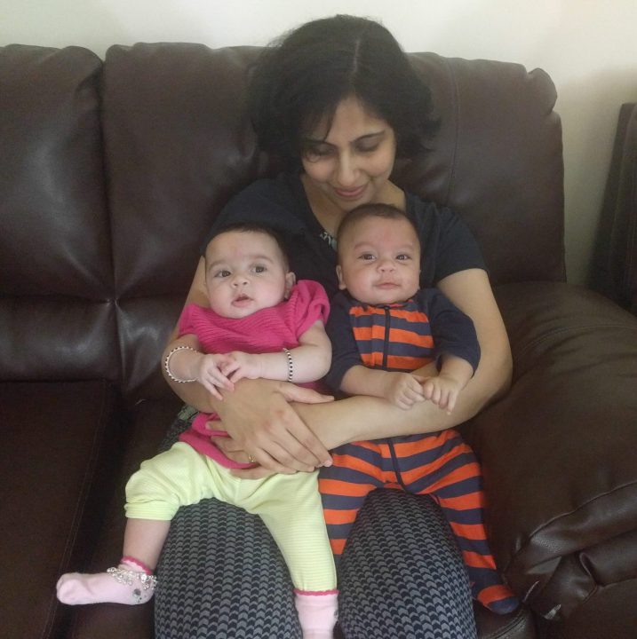 Woman sitting with her two babies on her lap