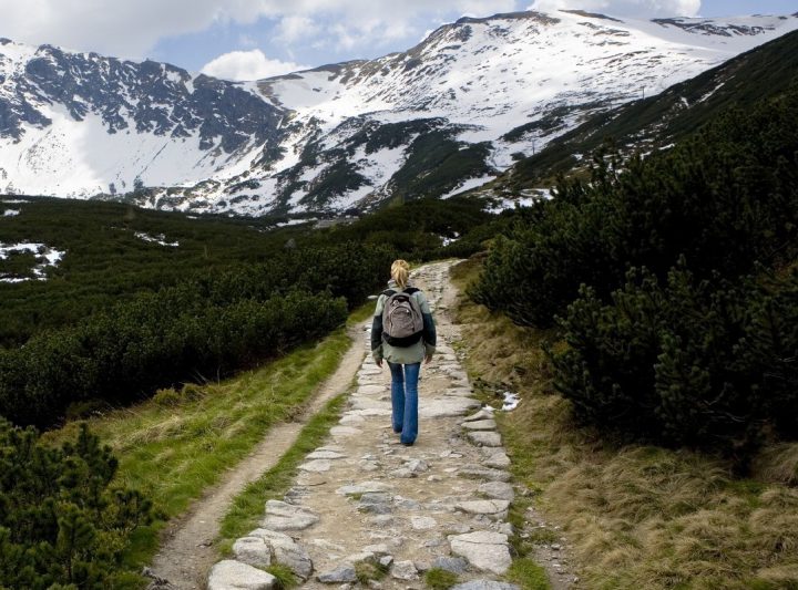 Woman hiking through snow-capped mountains
