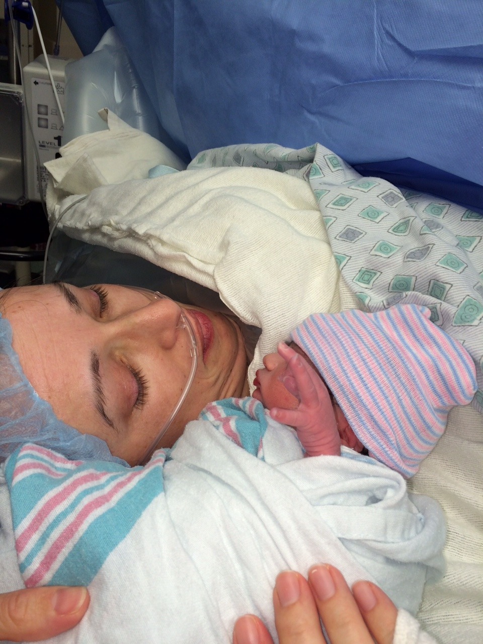 Woman holding her newborn baby in a hospital bed