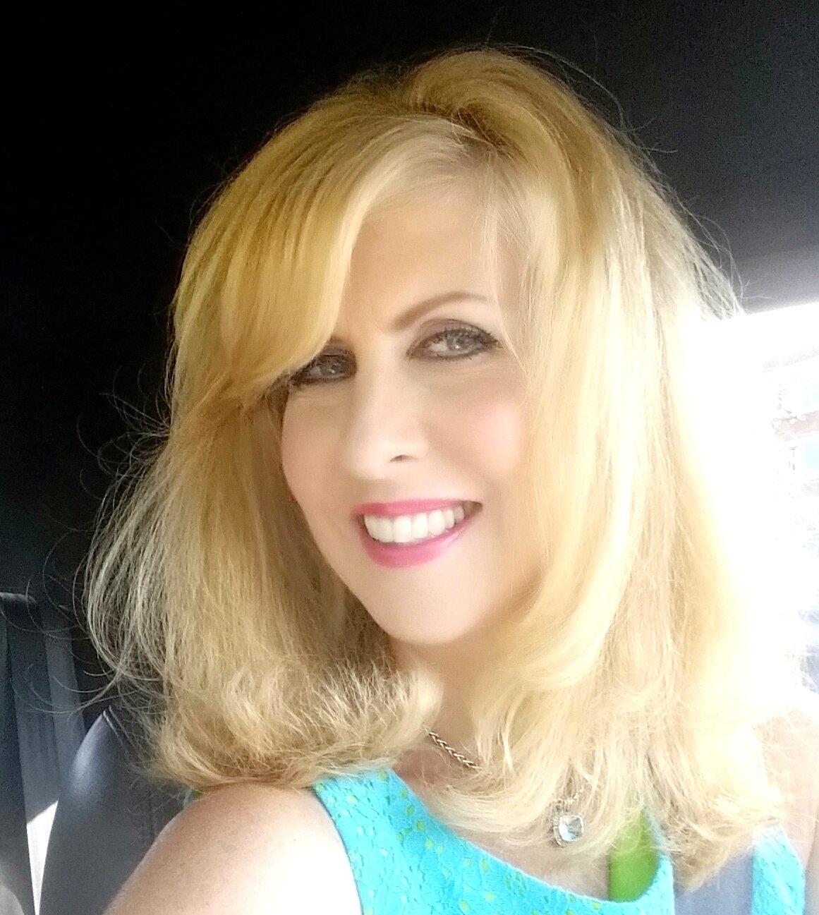 Selfie of a blonde woman wearing a blue top