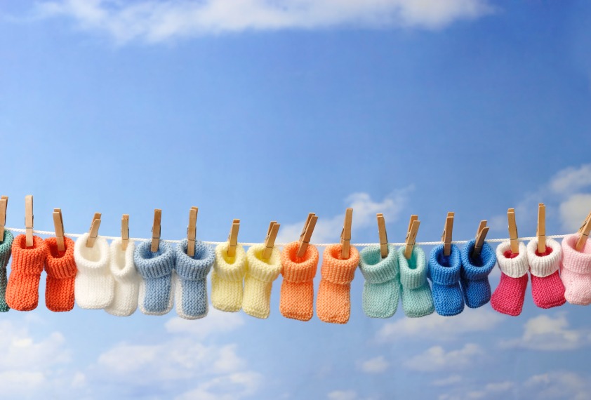 Knitted baby booties clipped onto a clothes line