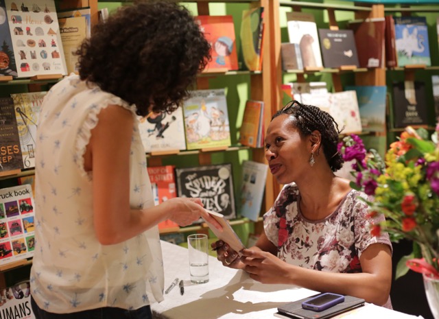 A woman having an author sign their book