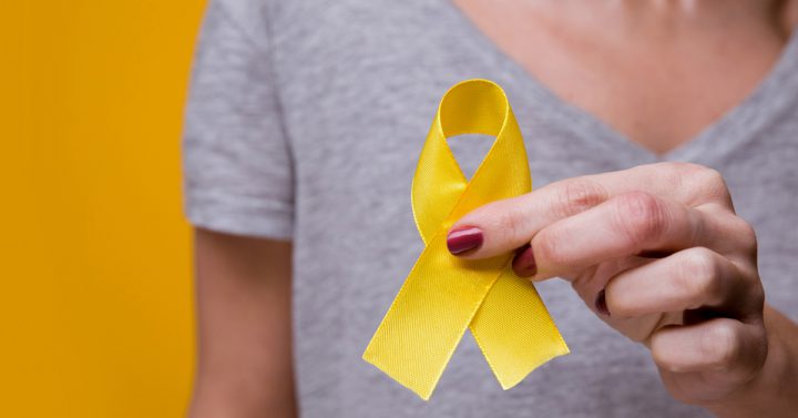 Woman holding a small yellow ribbon
