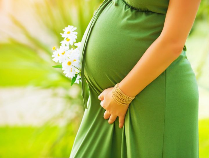 Pregnant women's belly in a green dress