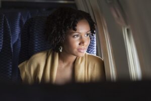 Female airplane passenger looking out of window
