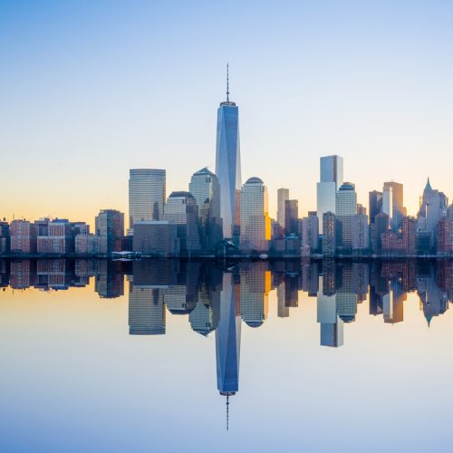 manhattan ny skyline with reflection on water at sunset